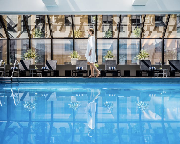 A woman walks by the large pool at the Intercontinental Hotel in Wellington, one of the best luxury hotels in New Zealand.