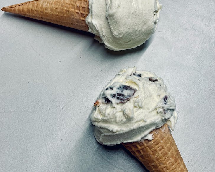 Two ice cream cones on a concrete background.