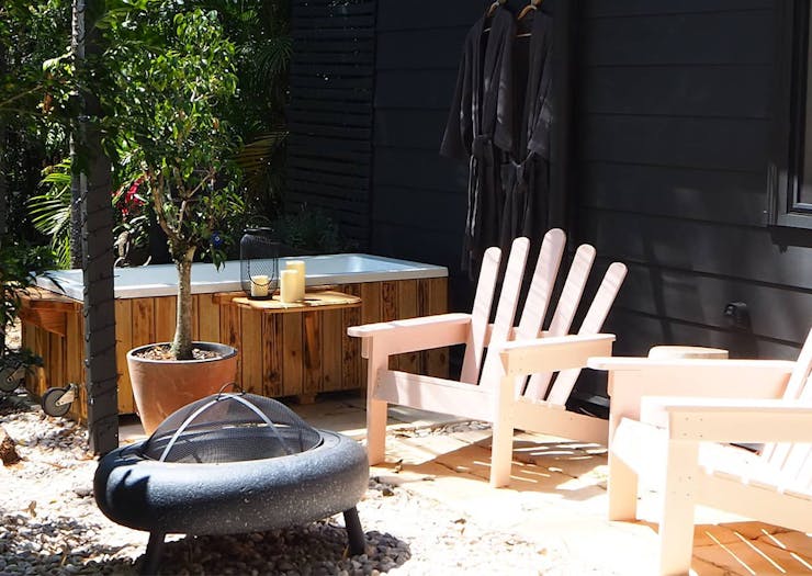 an outdoor bath and two garden chairs