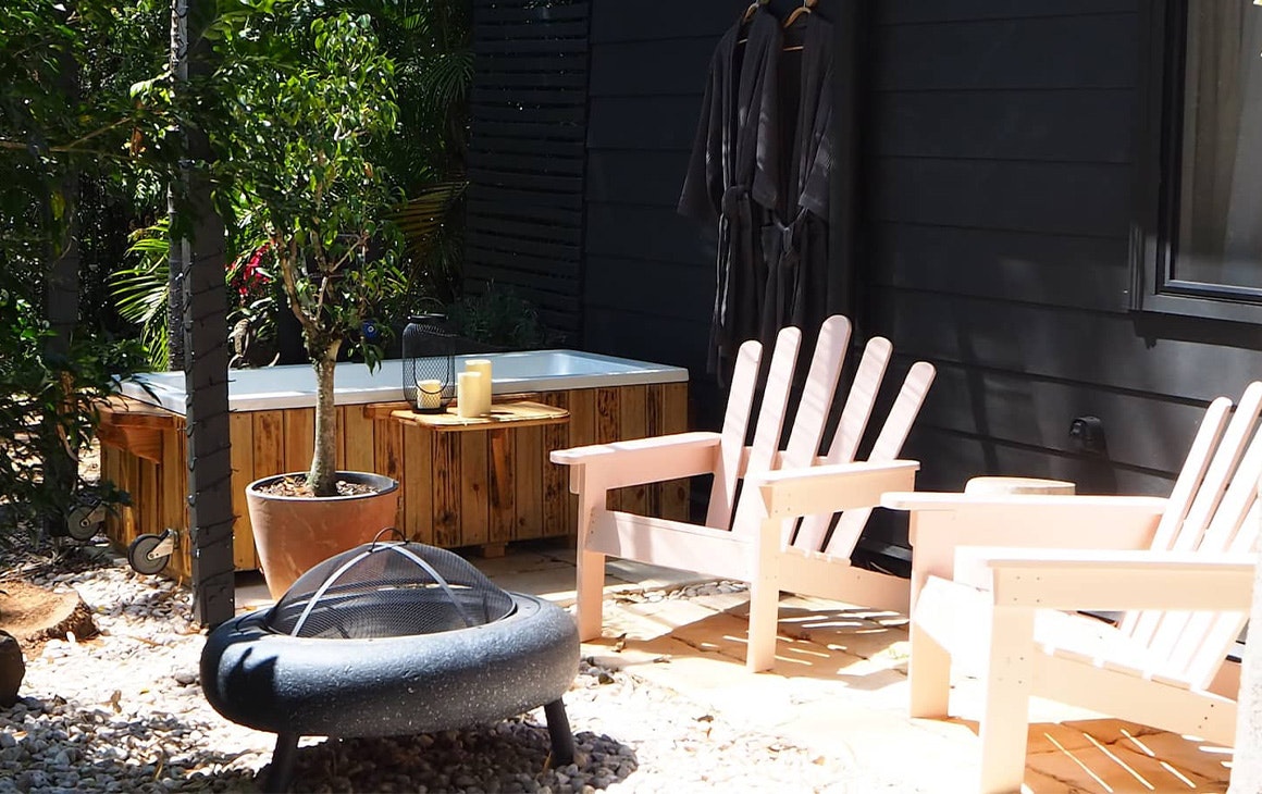 an outdoor bath and two garden chairs