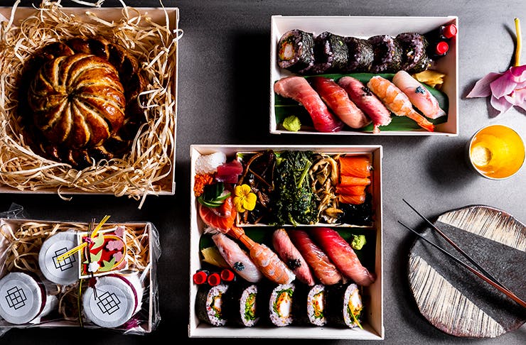 A box made of stone filled with sushi and sashimi.