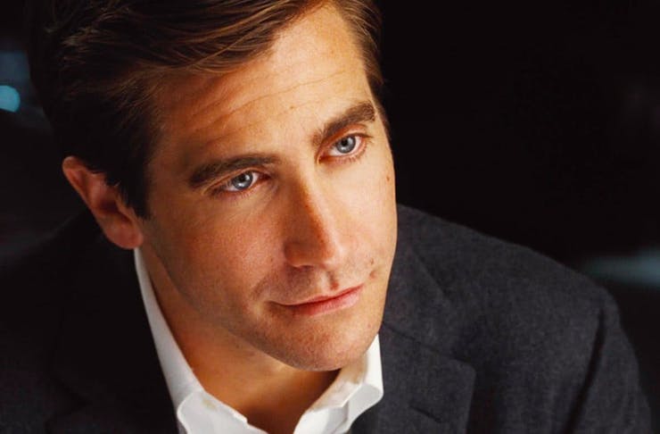 Jake Gyllenhaal in a suit, while pensively looking at the camera. 