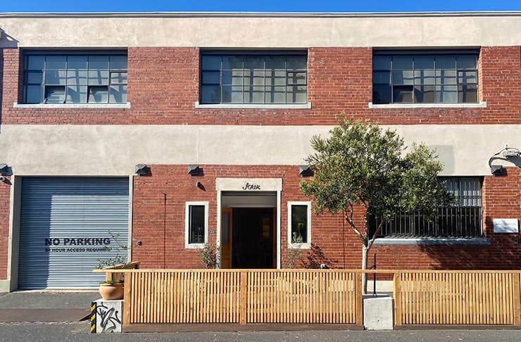 A brick building with a wooden fence out front.