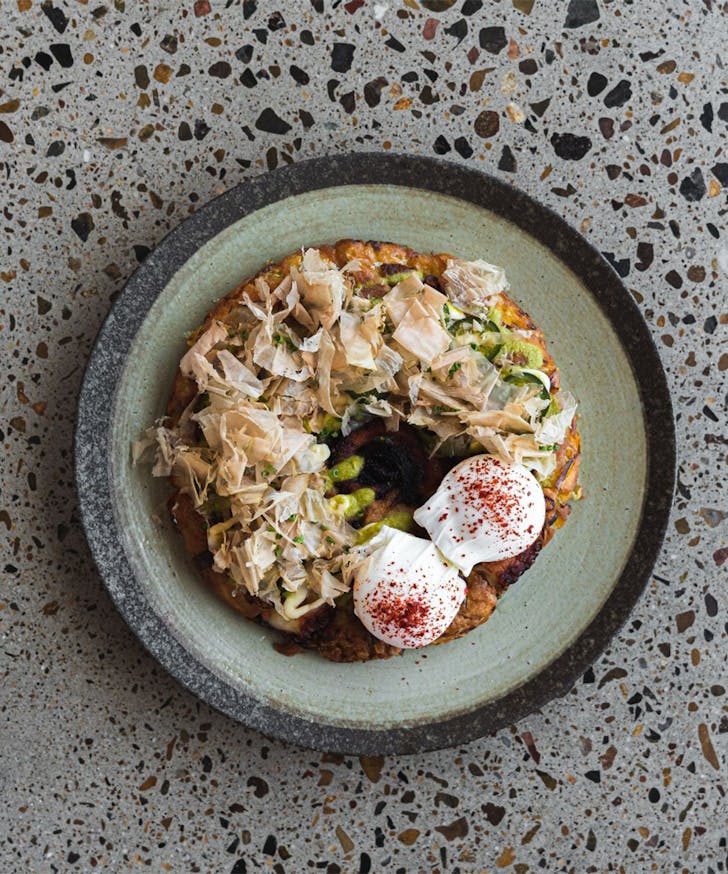 a cabbage pancake topped with two poached eggs