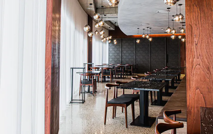 the interior of juju, with black walls, draped white curtains and pendant lighting