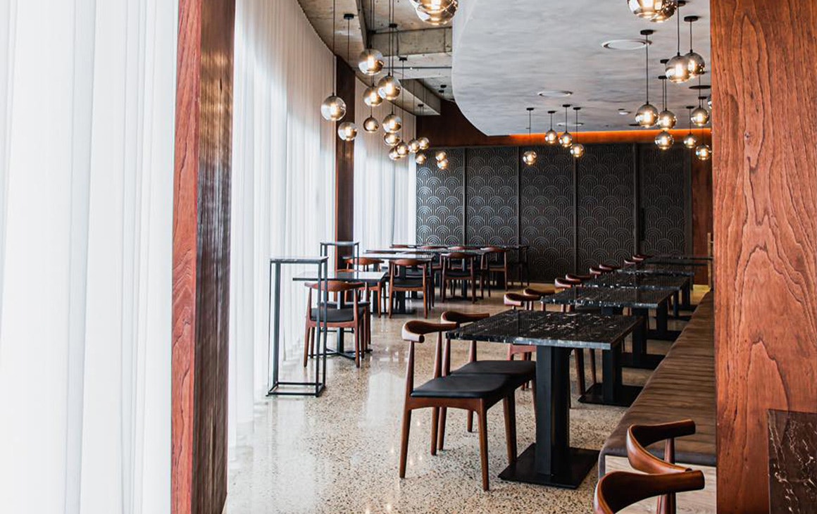 the interior of juju, with black walls, draped white curtains and pendant lighting