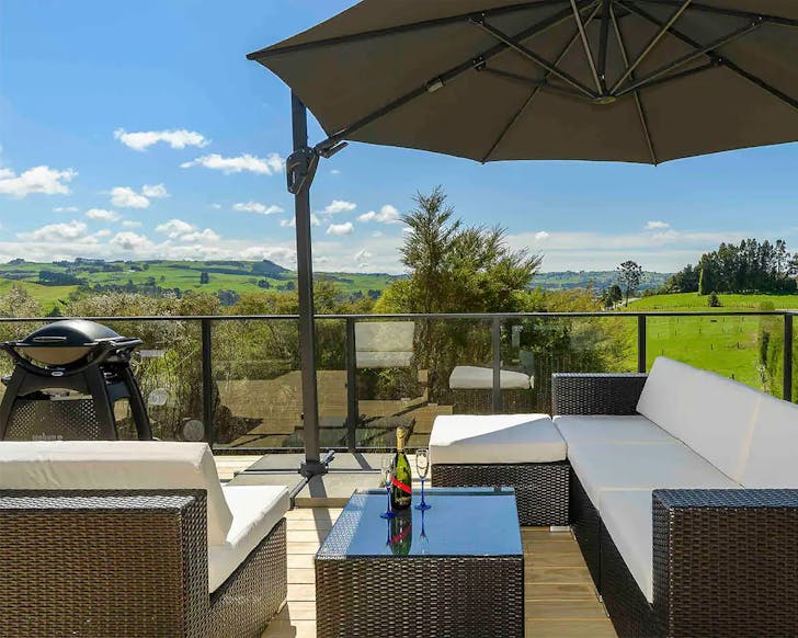 A lush patio area looks out over rolling hills.