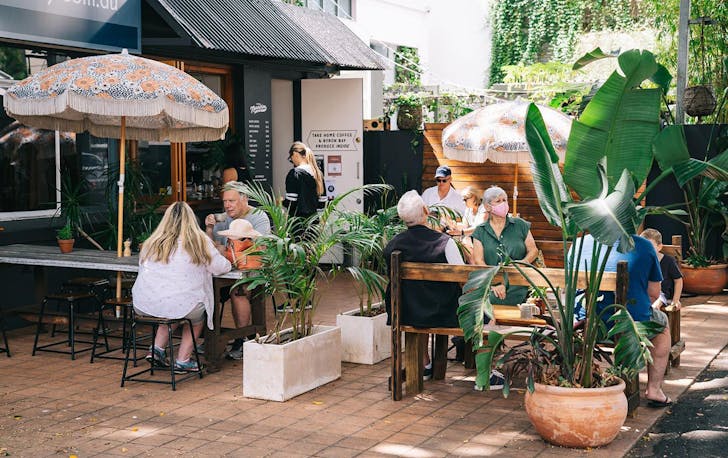 people sitting at picnic tables outside a kangaroo point cafe