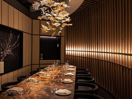 A gold-hued marble table and golden chandelier in a private dining room at Kazan restaurant. 