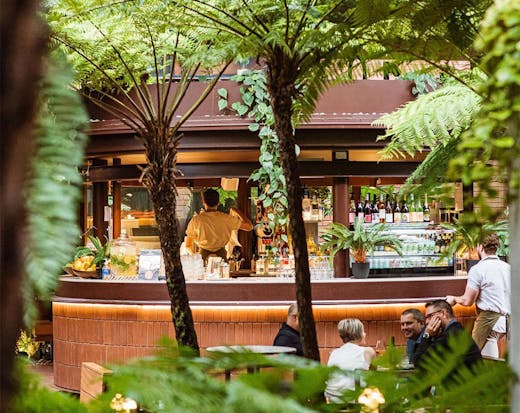 a glimpse of Kiki Kiosk's bar through leafy palms