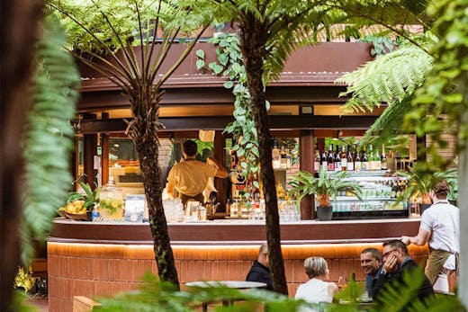 a glimpse of Kiki Kiosk's bar through leafy palms