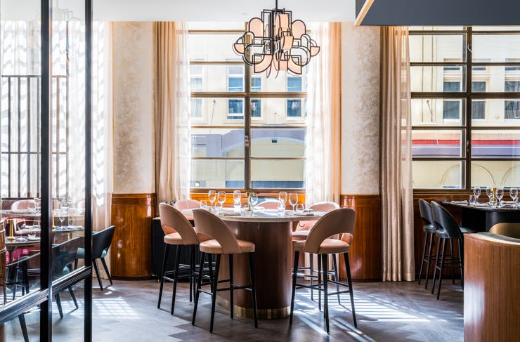 A dining table by a window at Kimpton Margot Sydney