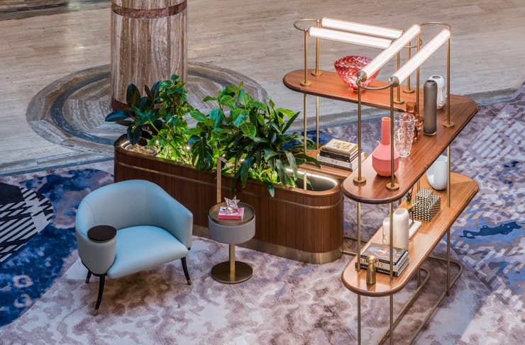A lounge chair and book shelf in the foyer at Kimpton Margot Sydney