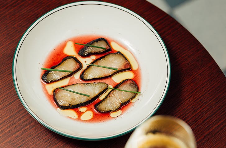Sliced kingfish in a bowl of flower vinegar dressing. 