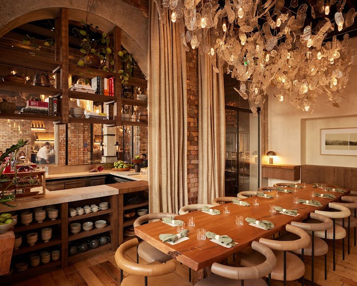 A beautiful, warm-looking private dining room and fish scale chandelier above.