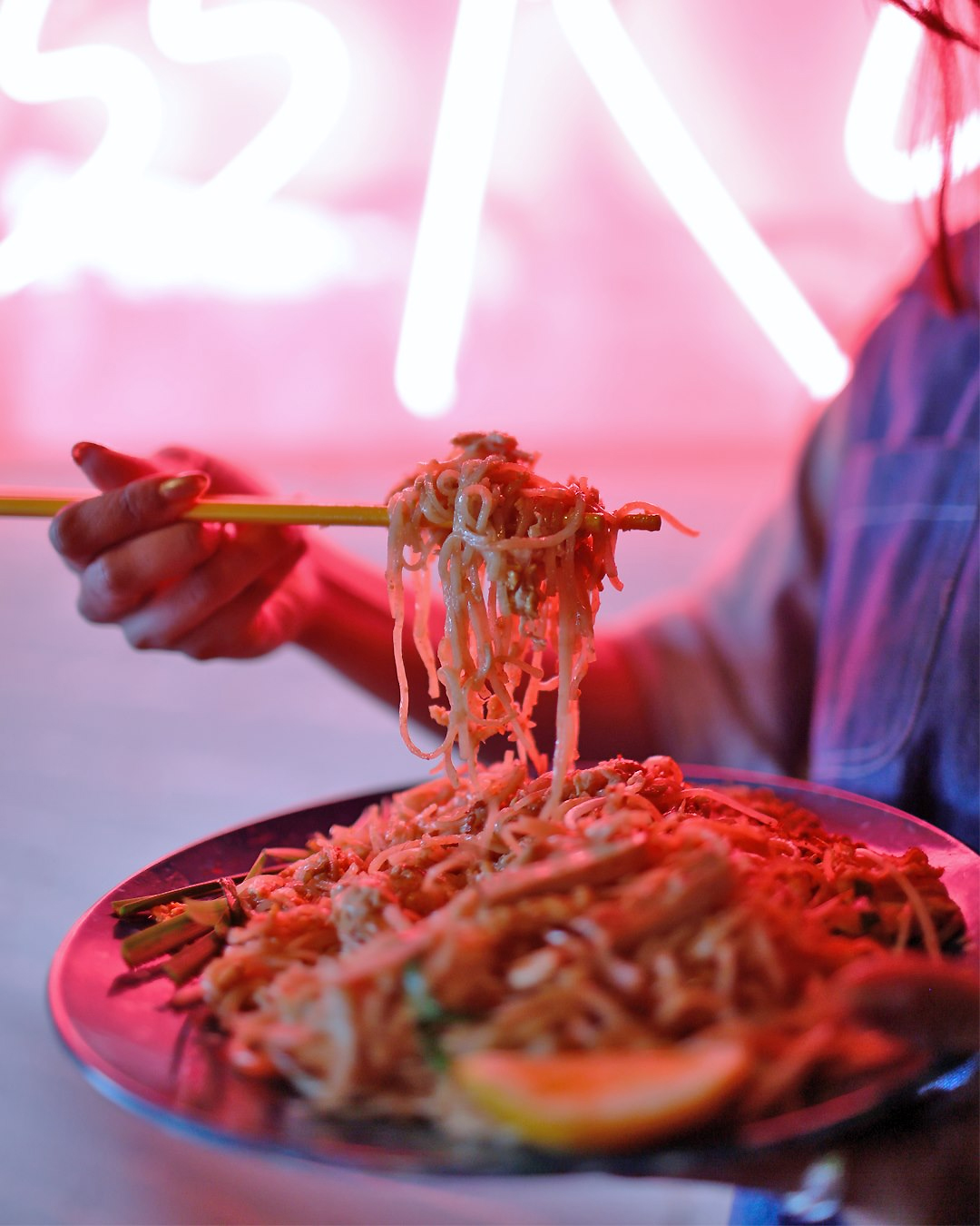 A heaping bowl of noodles with chopsticks full at Kiss Kiss