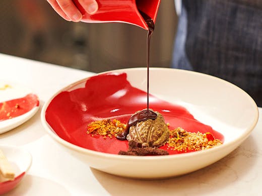 Chocolate being poured over one of the hand-crafted bespoke desserts at the KitKat Chocolatory in Sydney. 