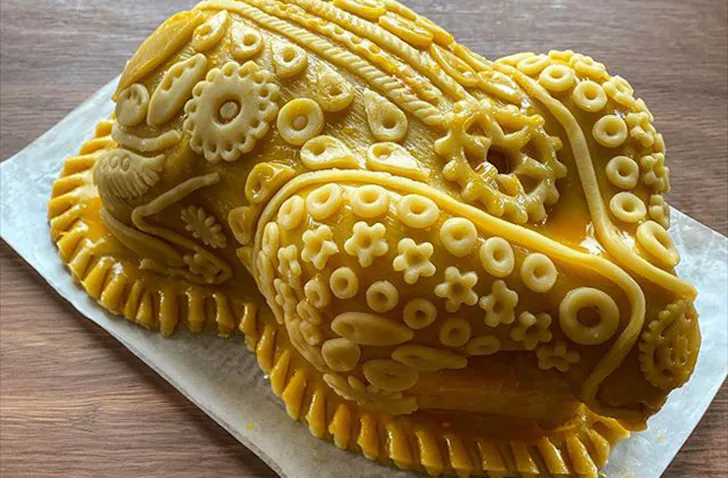 A chicken encrusted and decorated in pastry. 
