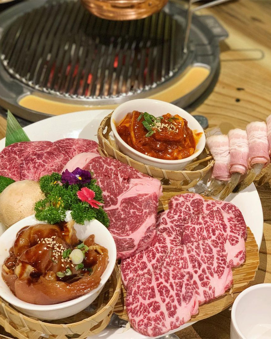 a board of meats next to a bbq at a brisbane korean bbq spot