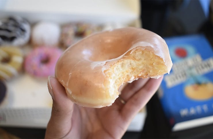 Krispy Kreme doughnut with a bite taken out of it.