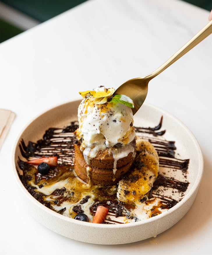 a stack of pancakes covered in ice cream