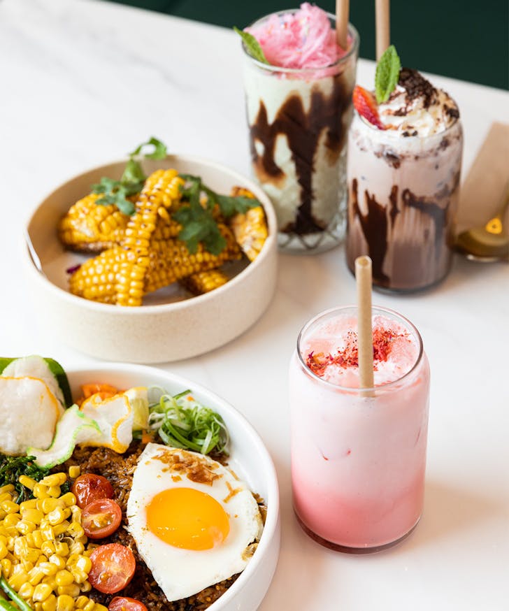 a selection of Indo dishes and colourful drinks on a table