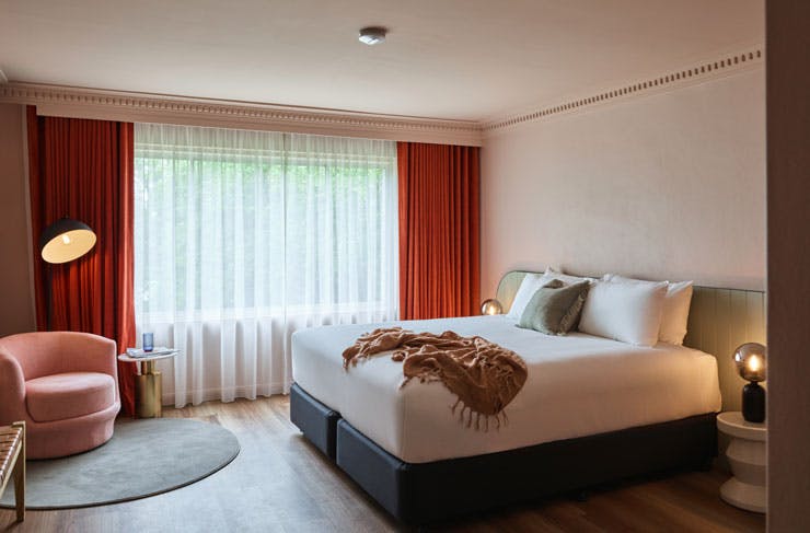 A suite at Kyah boutique hotel, complete with pink velvet chair and a large plush bed