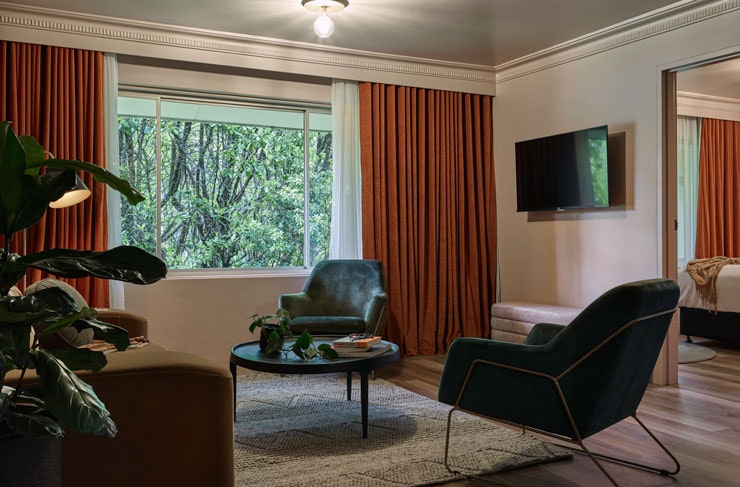 Velvet green armchairs in a living room at Kyah Boutique Hotel