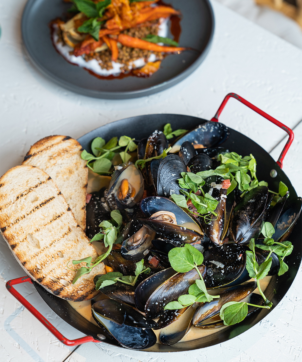 a bowl of mussels in white wine sauce