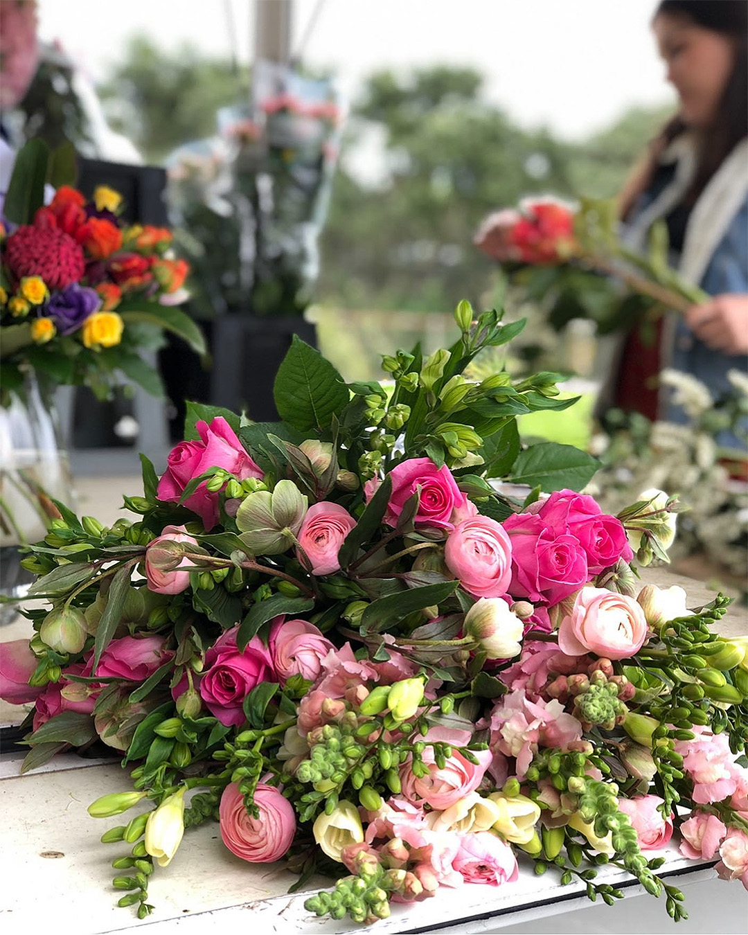 A person at La Femme Fleur flower truck makes an arrangement. This is one of the best flower delivery services in Auckland.