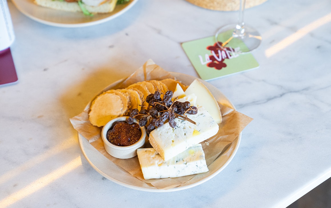 a cheese board with a glass of wine