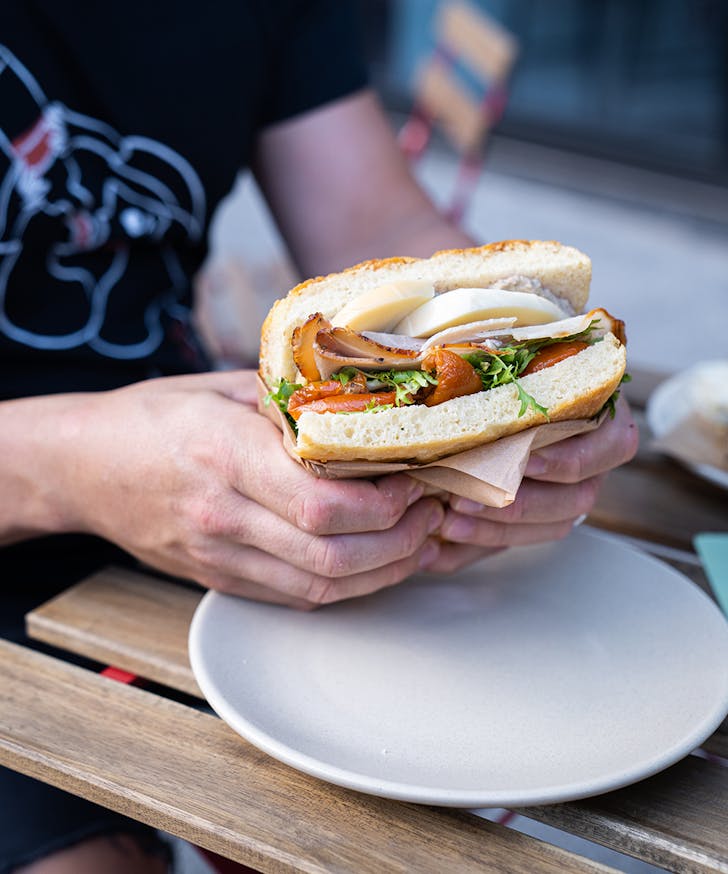 a person holding a focaccia sandwich