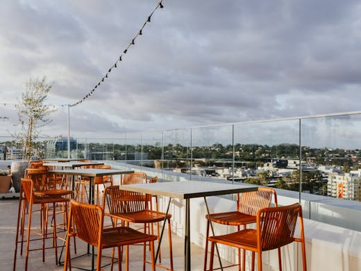 Orange bar stools on a rooftop bar