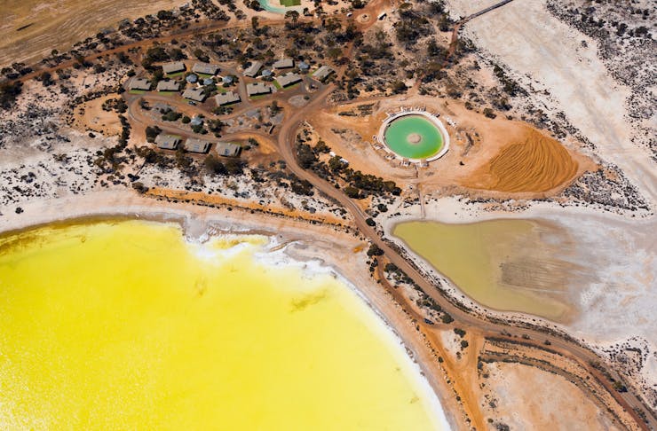 an aerial view of the yellow Lake Magic and turquoise saltwater pool near Wave Rock