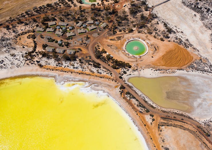 an aerial view of the yellow Lake Magic and turquoise saltwater pool near Wave Rock