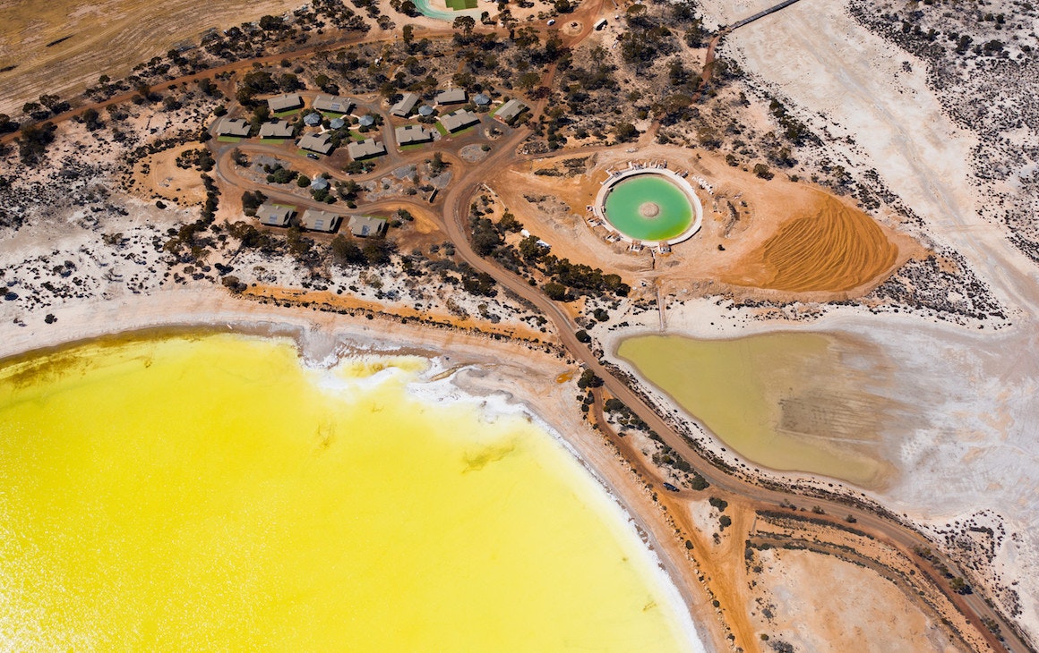 an aerial view of the yellow Lake Magic and turquoise saltwater pool near Wave Rock
