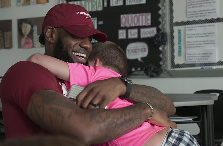 LeBron James gives a wholehearted hug to a little boy.