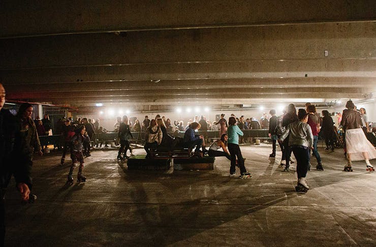 People rollerskating in an underground carpark.