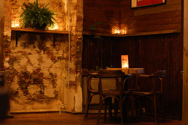 A small table sits in a candle-sit room at one of the best bars in Melbourne.