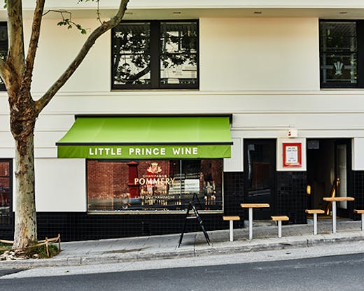 A small wine bar on a sloped street. Text on the awning reads 