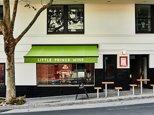 A small wine bar on a sloped street. Text on the awning reads 