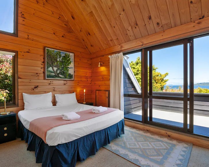 A lockwood bedroom from a Lake Terrace Airbnb, one of the best Airbnbs in TaupÅ for a nostalgic vacay. 