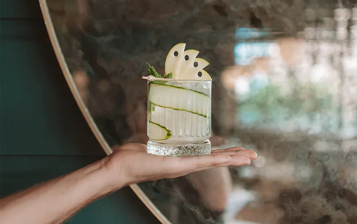 a hand holding a cocktail