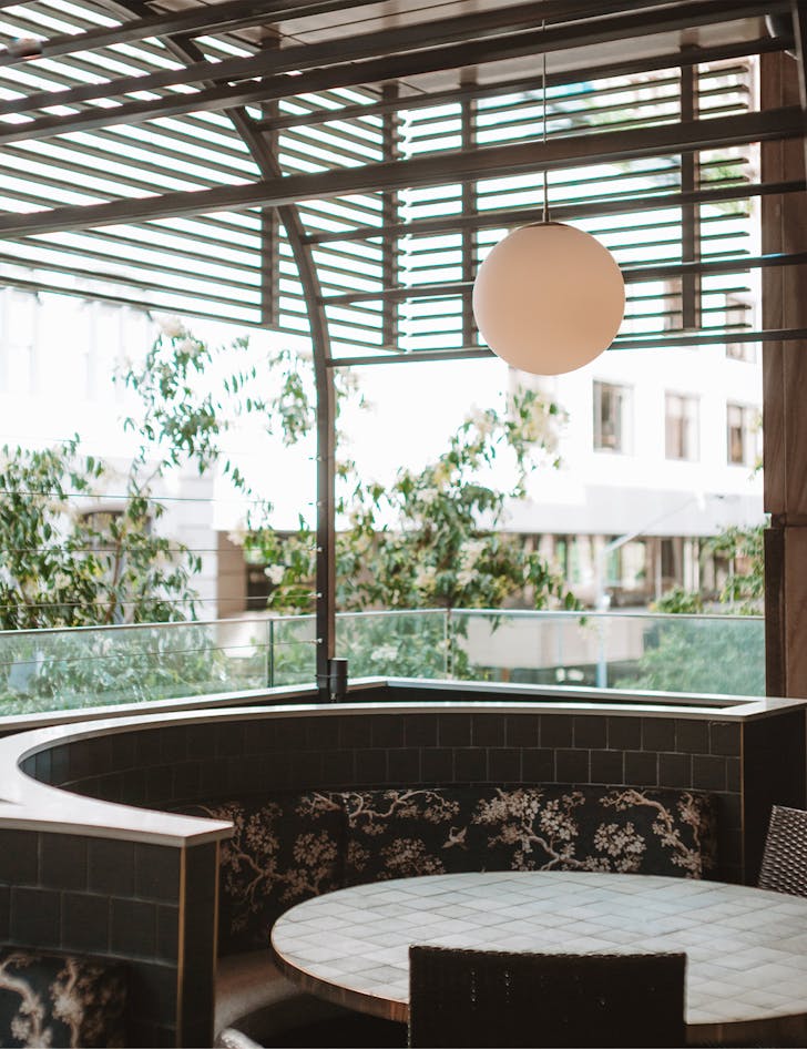 an outdoor balcony area with a round tiled booth table