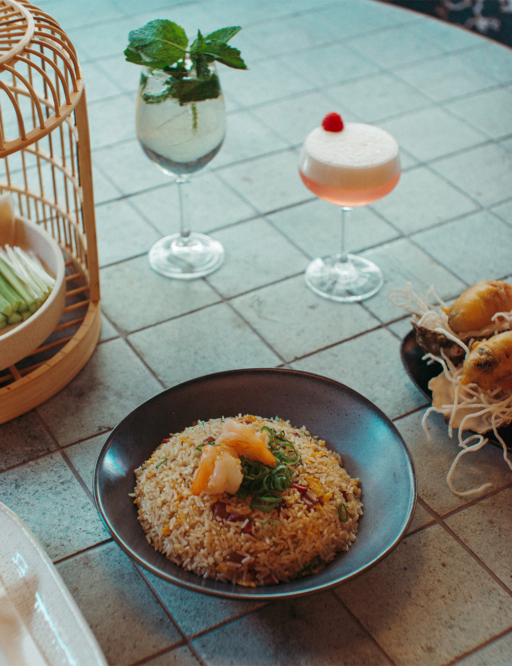 a fried rice dish on a table with cocktails