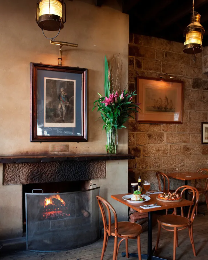 A cosy fireplace table at The Lord Nelson Brewery Hotel in The Rocks.