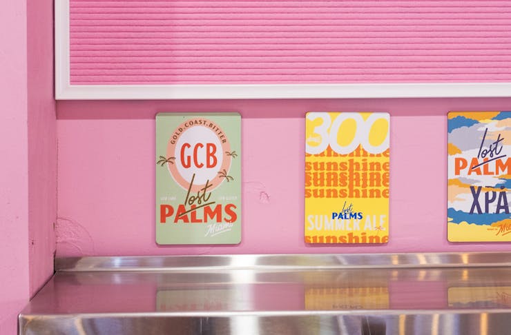 a row of tap signs on a pink wall