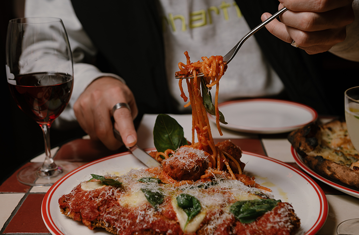 A person digging into spag served with one of the best parma in Melbourne at Louey's