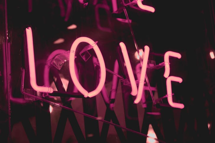 a pink neon sign that says 'love'