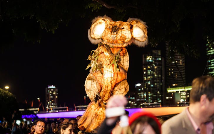 a koala lantern above a parade of people